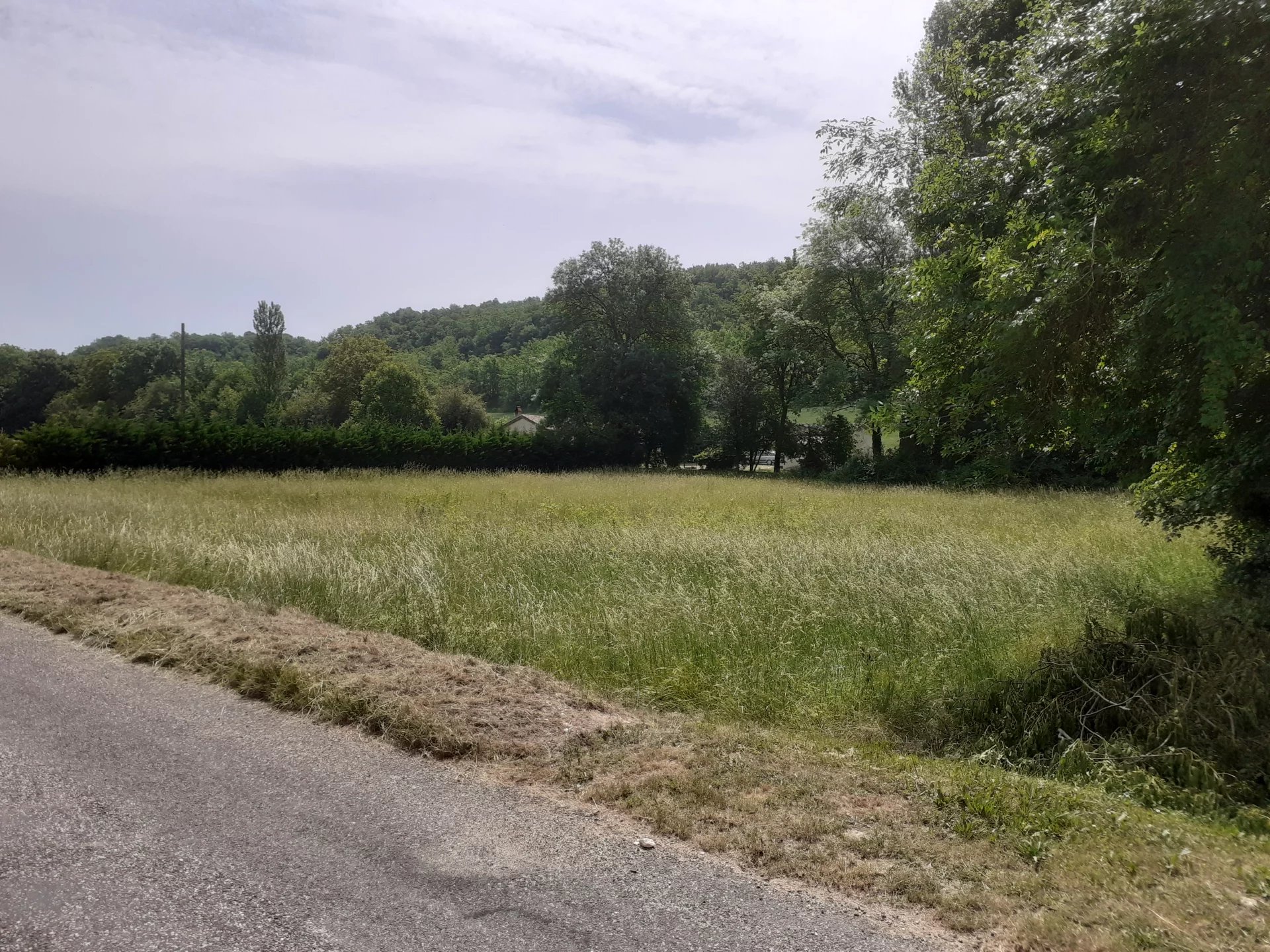 Terrain plat constructible à la périphérie d'un beau village