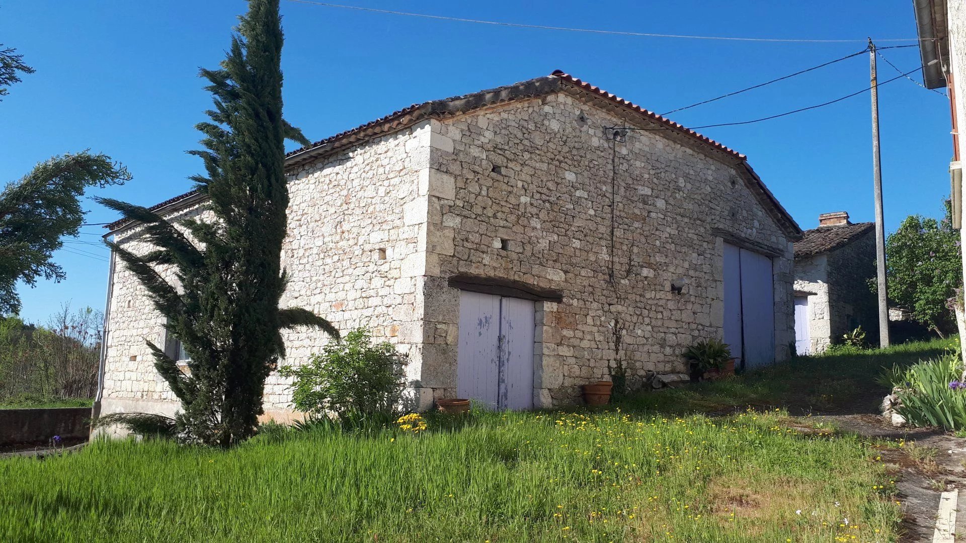 Maison en pierre avec granges et des bois