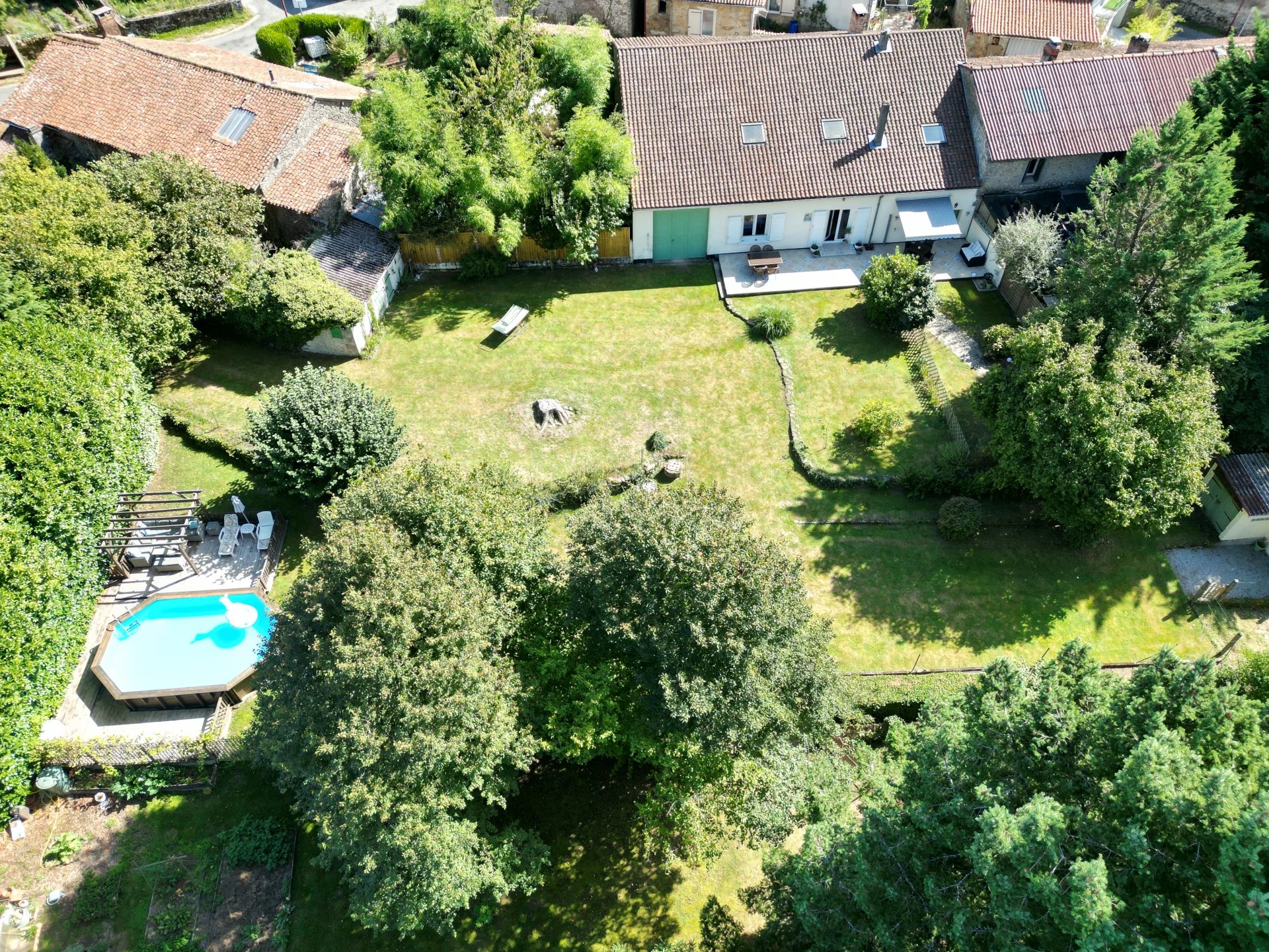 Maison principale et maison d'amis dans un cadre tranquille avec un grand étang et une piscine.