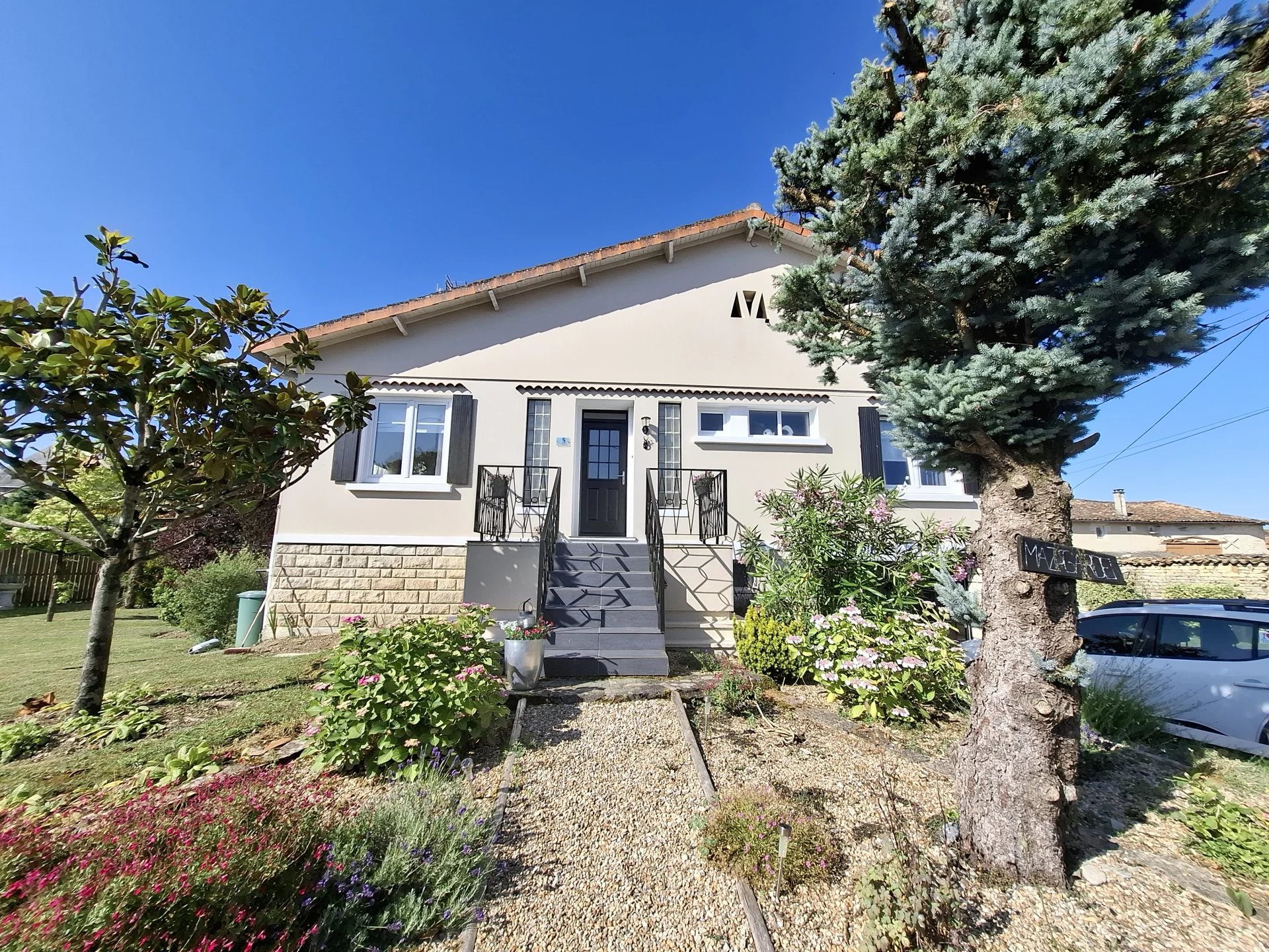 Maison de village joliment présentée avec de superbes jardins paysagers et une piscine